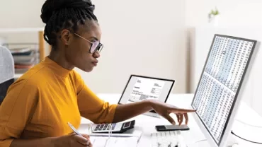 Person analyzing data on a computer monitor.