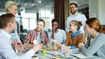 Group of people sitting at a table and discussing ideas in an office.