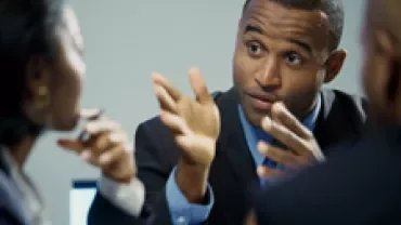 Business meeting with people engaged in conversation.