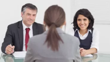 Person being interviewed by two professionals in an office setting.