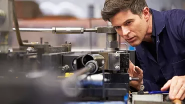 Person operating a machine in a workshop.