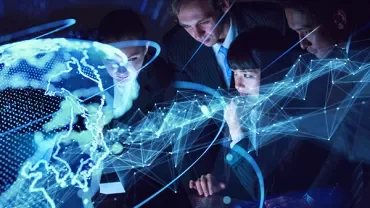 Group of people analyzing digital global map in a dark room.